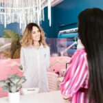 Two women chatting inside a stylish and contemporary hair salon.